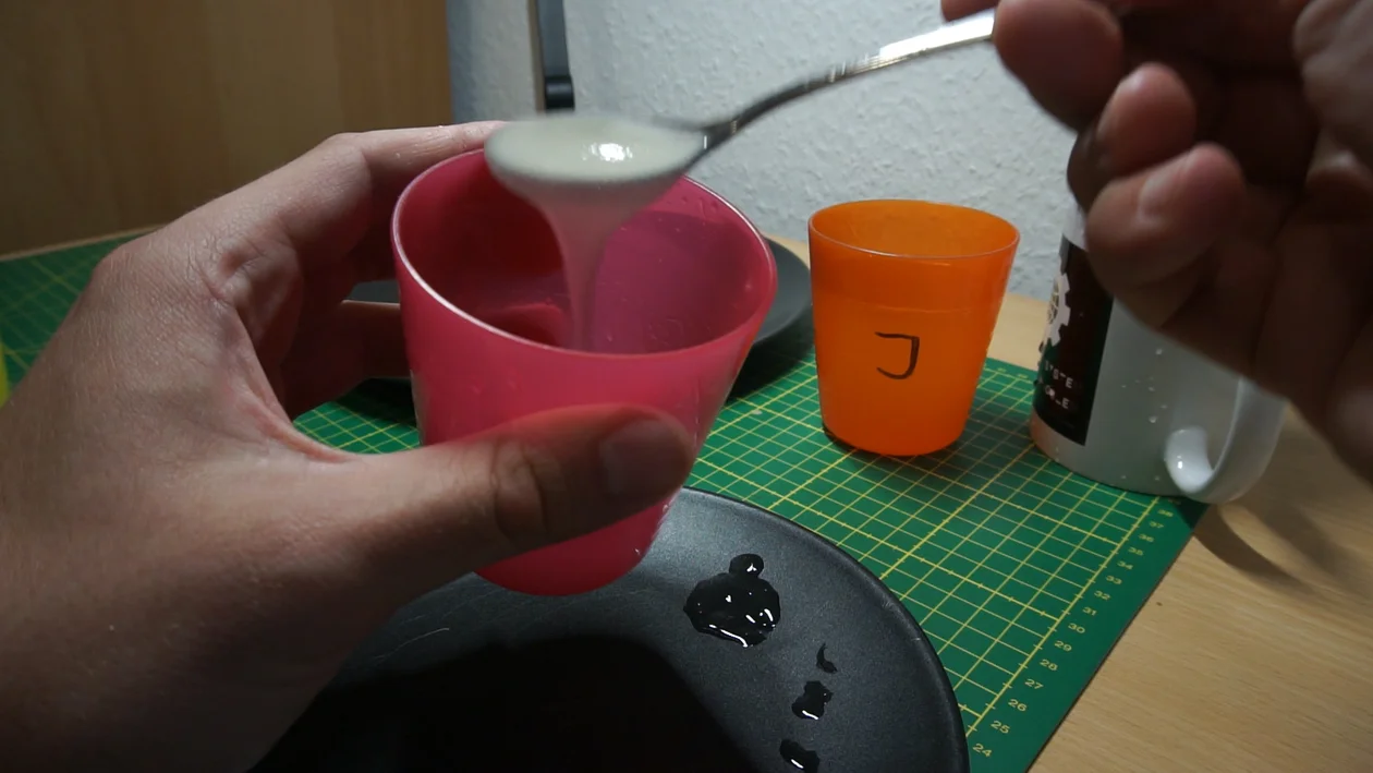 Concentrated carob bean gum mixture in a cup, running of a spoon. It’s very opaque and not gelatinous at all, but rather smooth and a bit slimy.